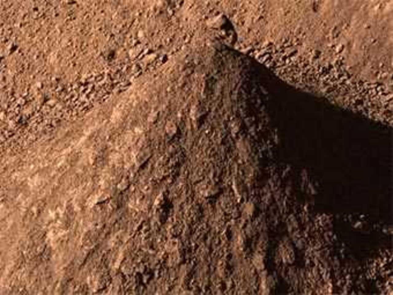 Из почвы, добытой при выкапывании траншей, "Феникс" строит горки. Фото NASA/JPL-Caltech/University of Arizona/Texas A&M University