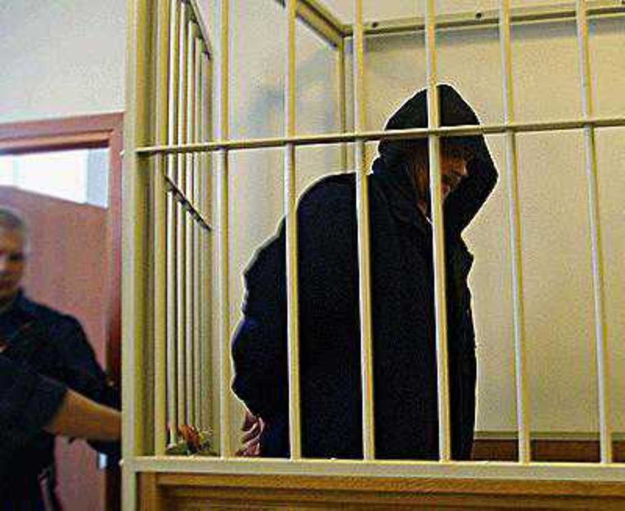 От прессы осужденный пытался скрыться за капюшоном...